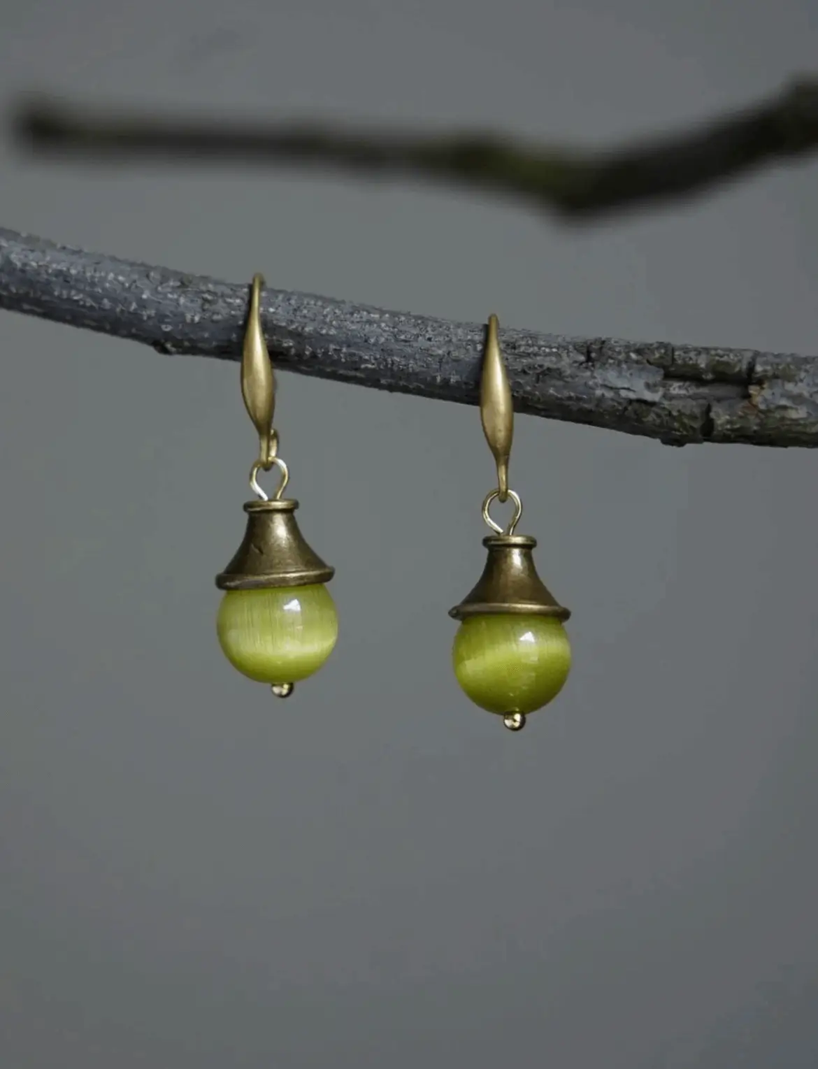 Yimo Green vintage handmade earrings hanging on tree branch with 925 silver gold-plated cat's eye stone earhooks