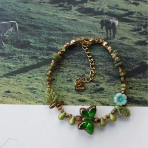 Green butterfly bracelet features vintage Czech beads and nature-inspired elegance.