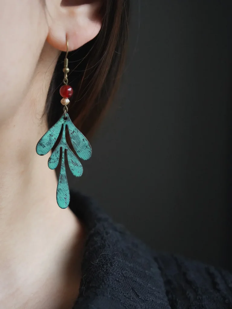 Brass dangle earrings worn by model highlight handmade beauty while adding a touch of vintage charm to everyday style.