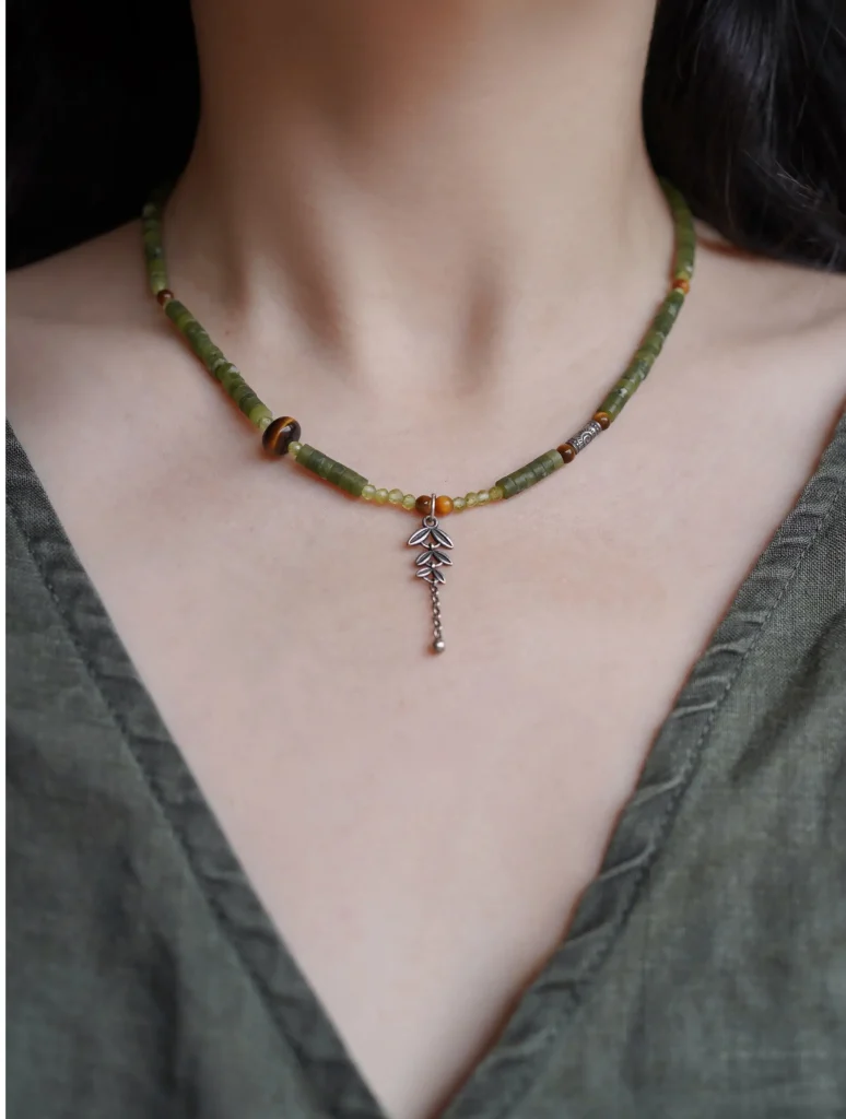 Model wearing a one-of-a-kind handmade necklace with natural stones and hand-painted details.