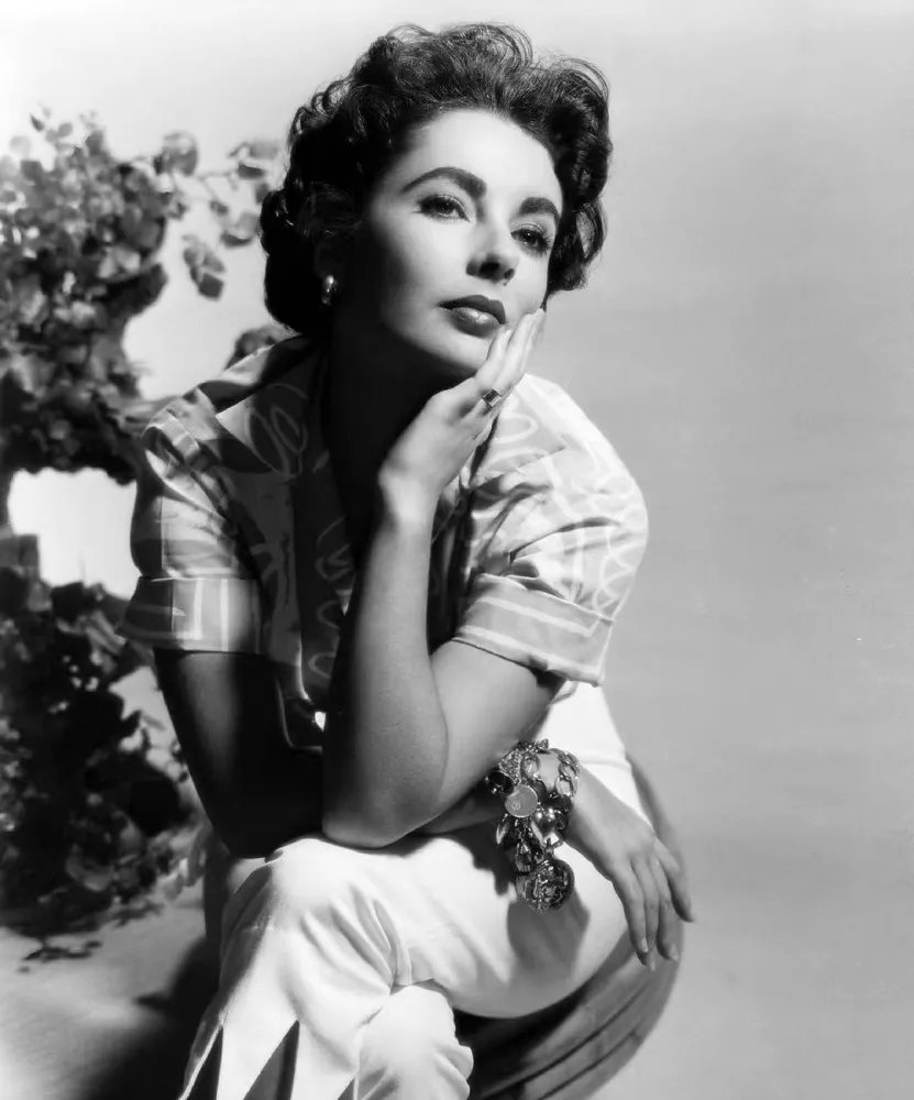 Illustration of Coco Chanel, featuring her iconic accessories and symbolic motifs such as the Maltese cross, lucky number 5, and wheat sheaf.