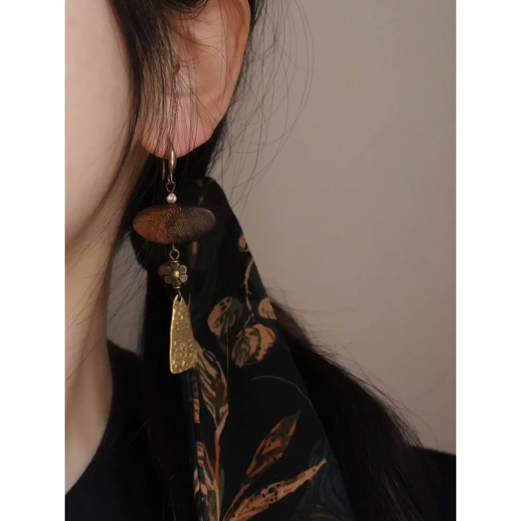 Woman wearing handmade Zen-inspired vintage earrings made from brass and wood beads