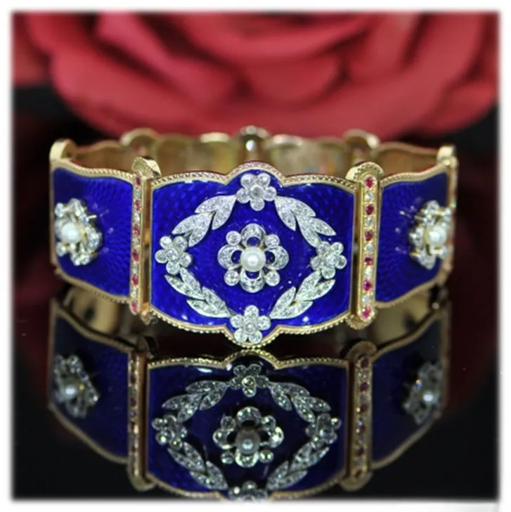 An illustration of a large enamel bangle in blue, showcasing the bold and intricate design typical of mid-Victorian statement jewelry, reflecting the prosperity and grandeur of the era.