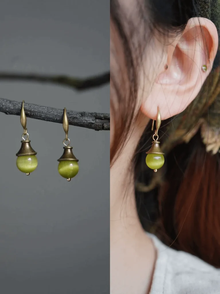 Handcrafted vintage earrings with green Cat’s Eye stone, capturing the charm of summer light.