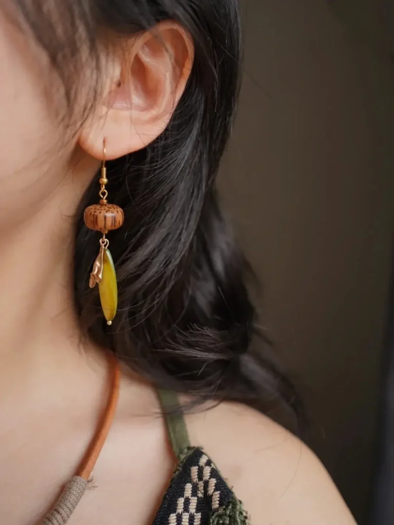 Handmade green leaf dangle earrings crafted from natural Nepalese coconut wood in Bohemian style.