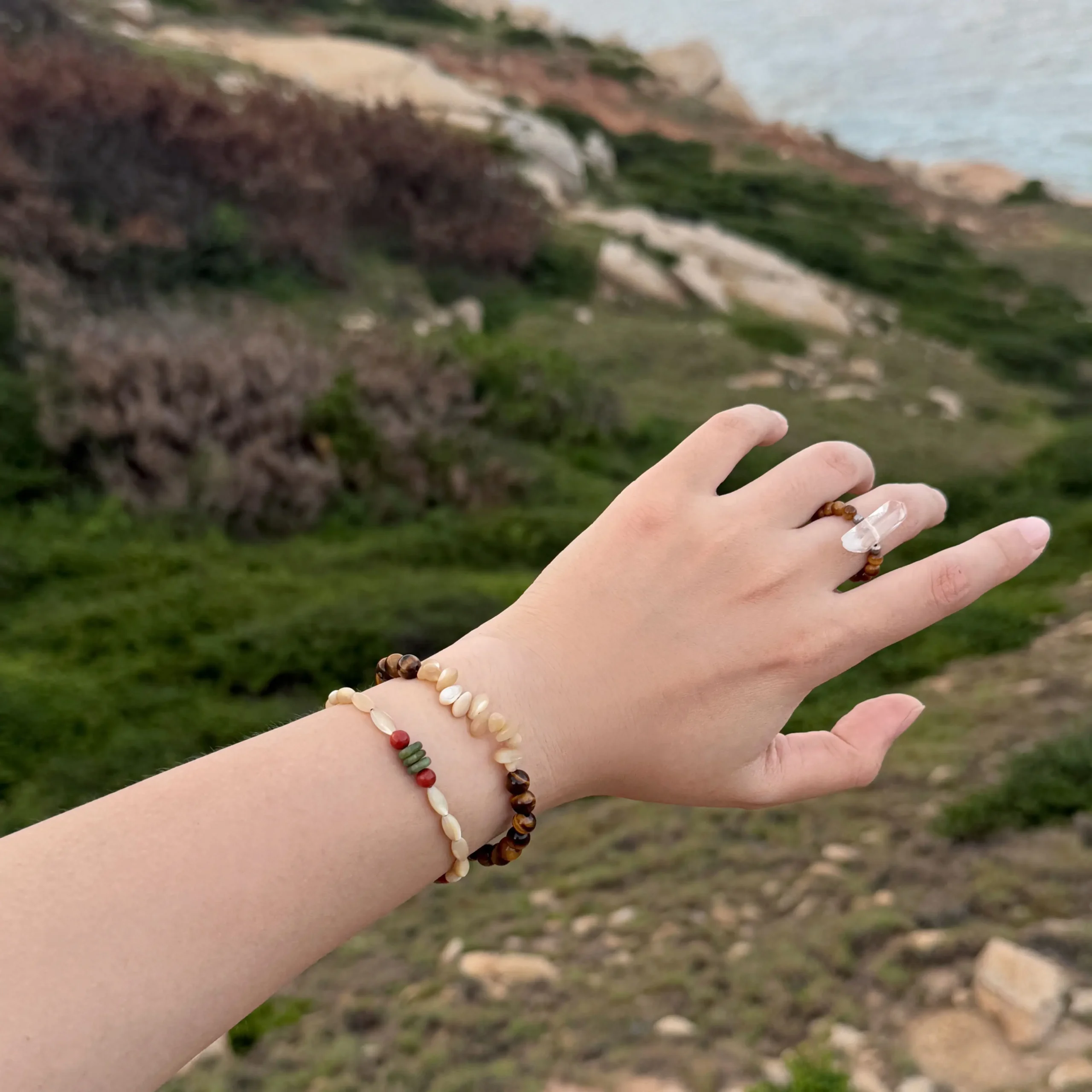Stacked beaded bracelets shown outdoors, highlighting their handmade design and versatile style for everyday layering.
