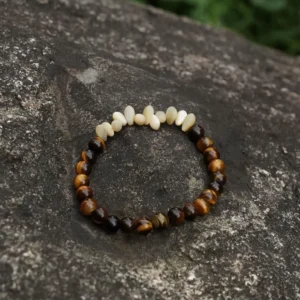 Handmade Tiger’s Eye stretch bracelet accented with horseshoe conch beads for daily elegance and empowering style.