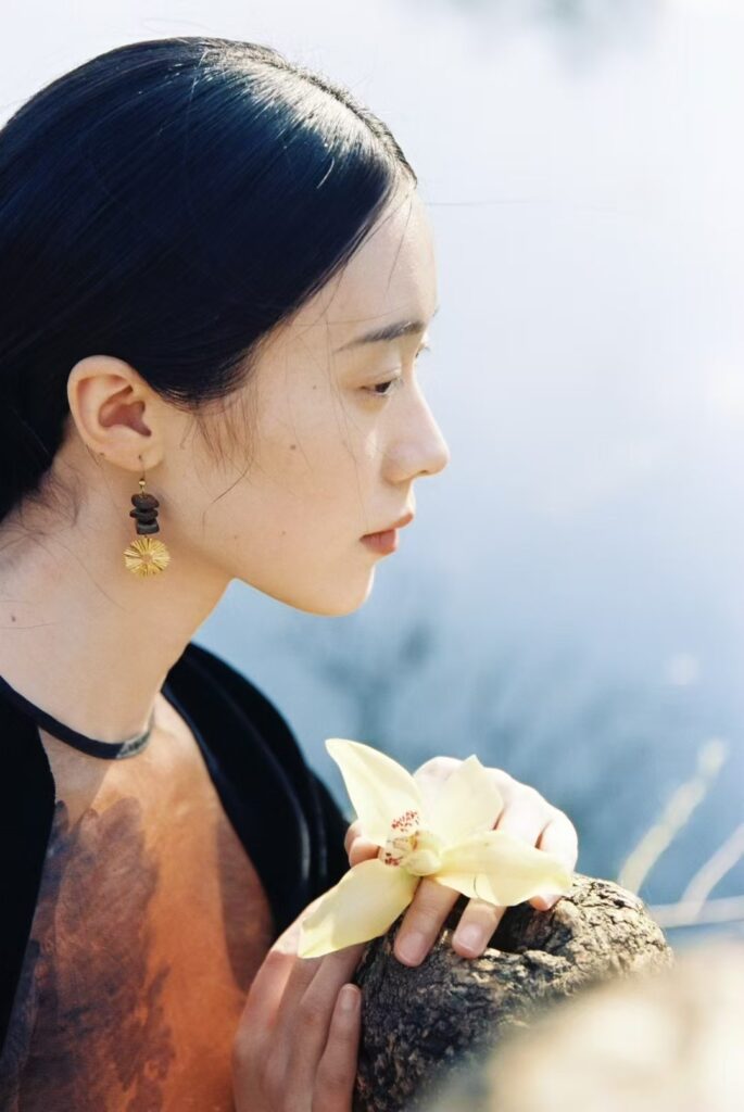 Model wearing Jewea handmade vintage earrings in a natural outdoor setting