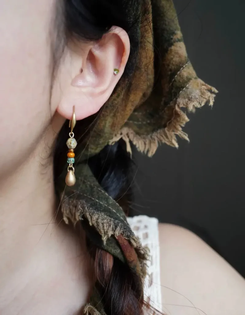 Model wearing handmade earrings with 925 sterling silver gold-plated hooks