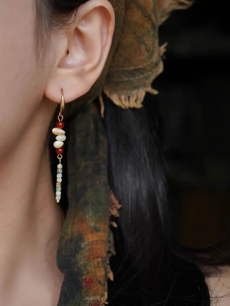 Model showcasing handmade earrings, highlighting craftsmanship and elegant wearable design.