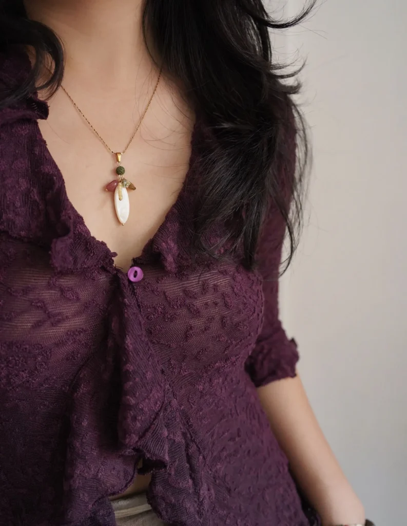Pendant necklace enhances V-neck outfits, adding elegance and effortless style for everyday wear.