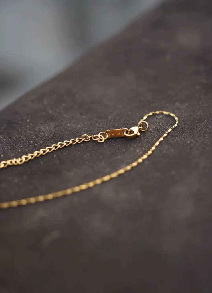 Close-up of steel-titanium chain highlights durable construction and sleek, modern design for everyday wear.