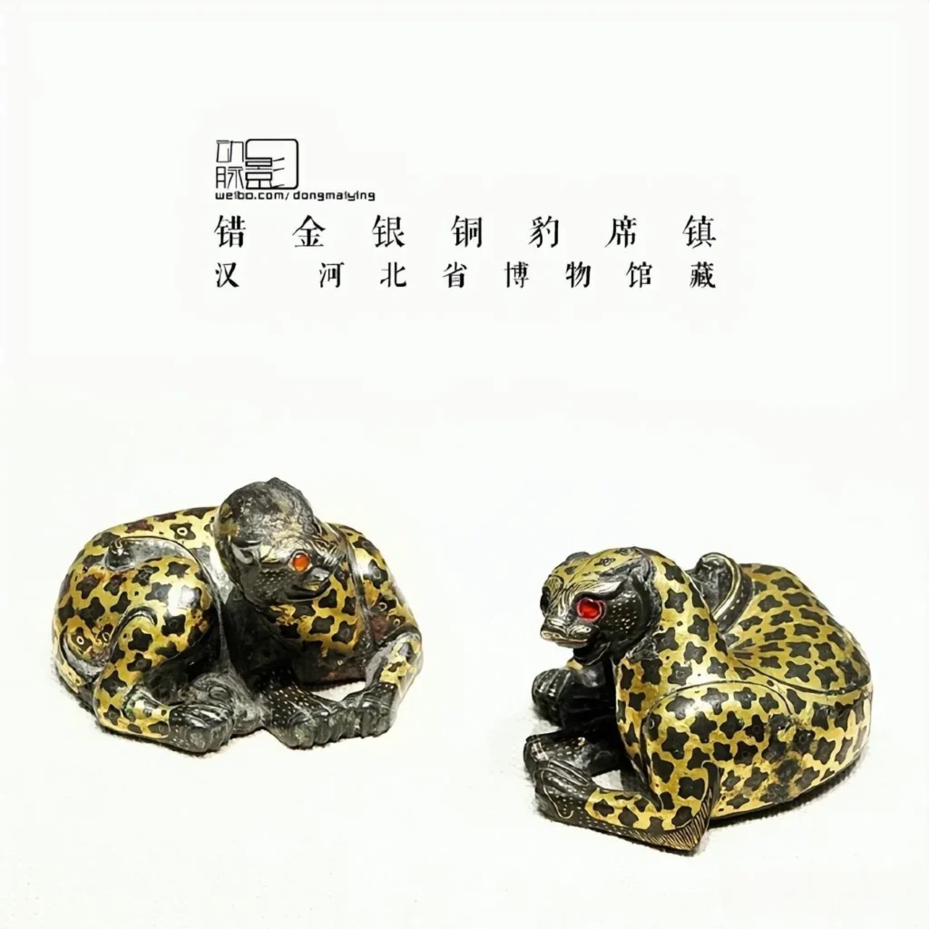 A vintage handmade Han dynasty bronze leopard mat weight crafted as a crouching leopard, with intricate gold and silver inlay highlighting its spotted coat and muscular form.