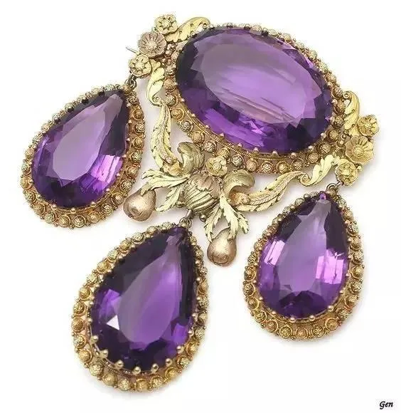 A beautiful brooch featuring a purple amethyst and gold.