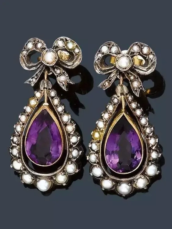A pair of earrings featuring purple amethyst and pearls, with a two-tone gold and silver design.