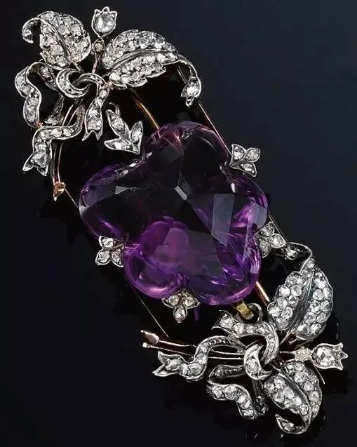  A brooch that can also be worn as a pendant, featuring a large amethyst surrounded by rose-cut diamonds.