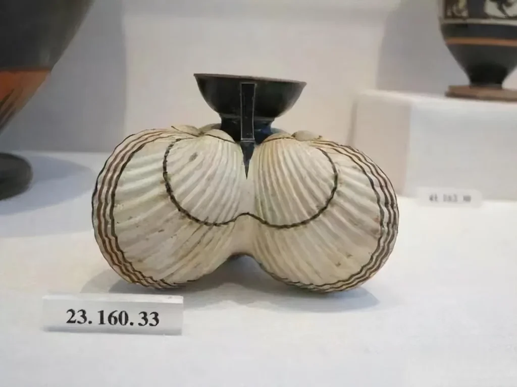  An illustration of an ancient Greek oil flask made from a seashell. The flask's shape mimics the natural form of a seashell with fluid lines, possibly made from materials like clay or bronze, showcasing the ancient artisans' clever use of natural forms.