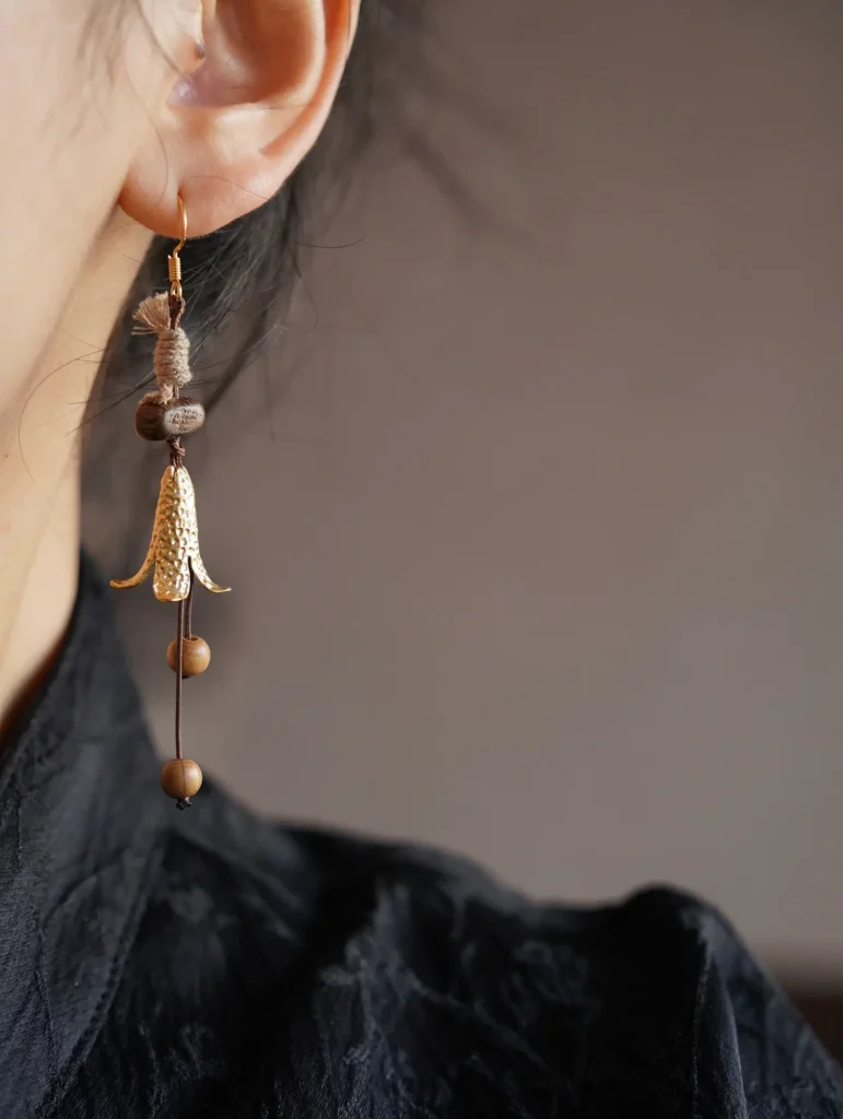 Woman wearing handmade autumn earrings showcasing natural materials and lightweight comfort.