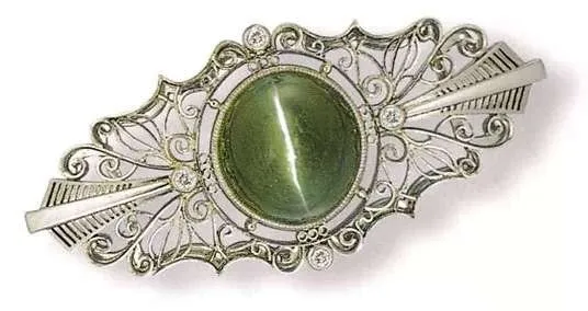 An image of a chrysoberyl cat's eye gemstone. The gem is typically cut into a cabochon shape, featuring a bright, straight cat's eye light band that moves with the light, with a clear crystal and a brilliant luster.