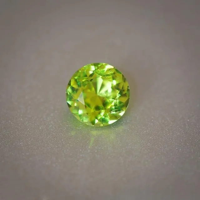 An image of a loose chrysoberyl gemstone. The gem typically appears in colors ranging from yellowish-green to yellow or brownish-yellow, with a clear crystal and a bright luster.