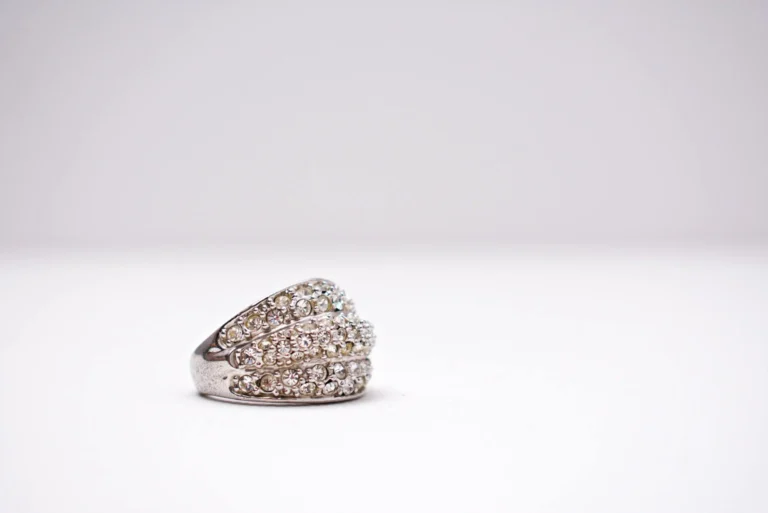 Close-up of a stylish diamond ring on a minimalist white background, highlighting diamond quality and the 4Cs