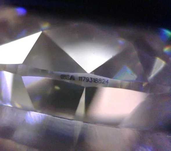An illustration of a diamond's girdle inscription, showing the laser-engraved GIA report number that provides a unique identifier to verify the diamond's authenticity and grading report.