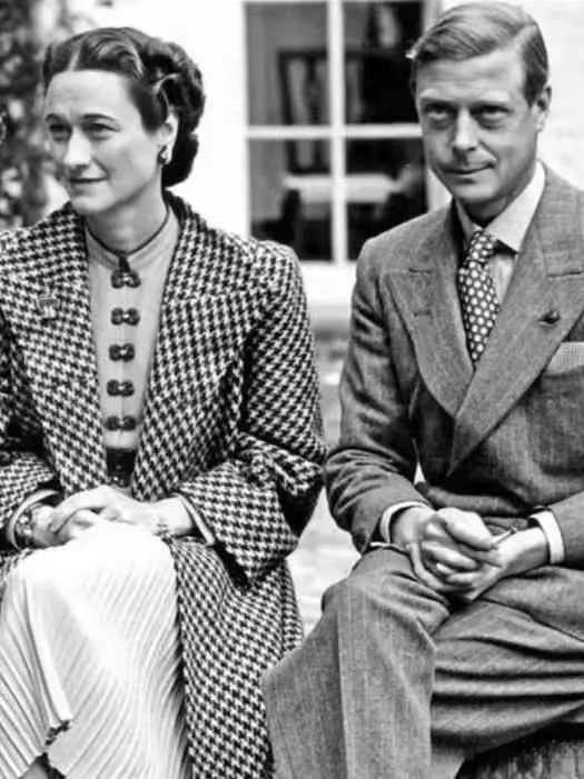A fashion illustration of the Duchess of Windsor, Wallis Simpson, elegantly dressed in a tailored coat featuring a classic houndstooth pattern.
