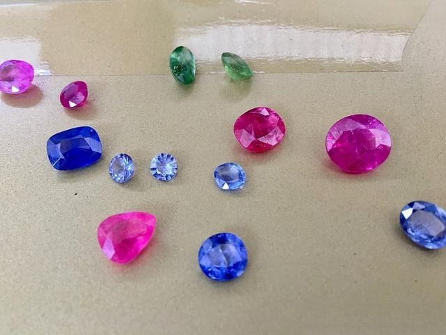 Gemstone collection from various origins, featuring Vietnam Pink Sapphires. The larger heated stone is at the top left, while the others are lighter in color with strong color zoning.