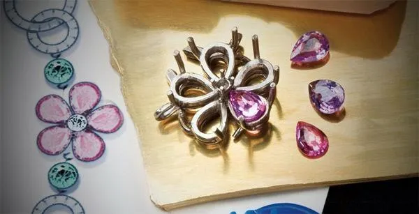 A jeweler manually sorting and selecting gemstones by color, cut, and size, preparing them for the setting process.