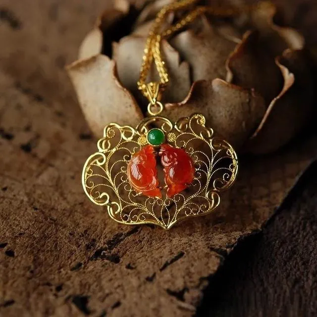 Red and green gemstones set in a gold, flower-shaped pendant, following the standards in the Jewelry Setting Quality Guide.