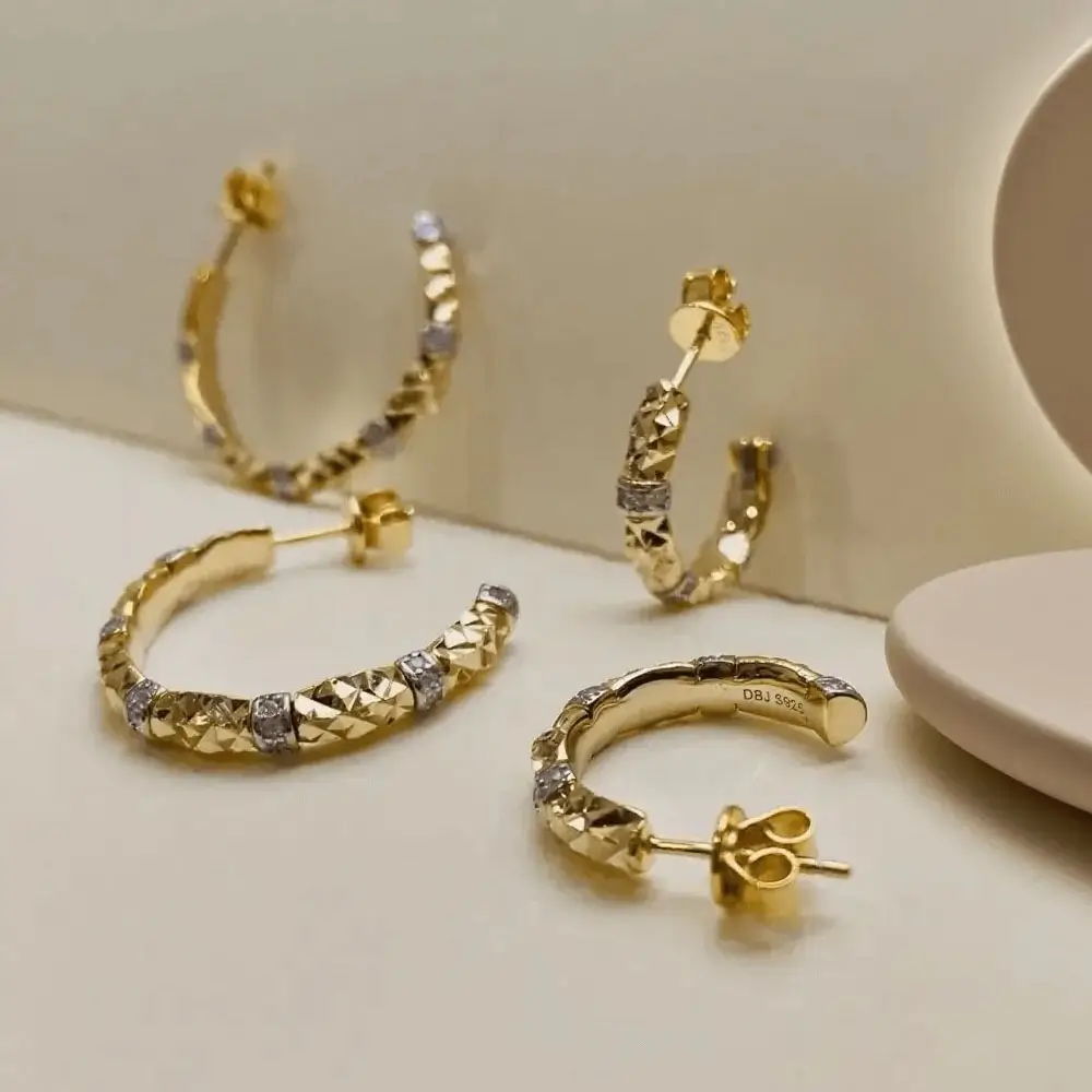Gold tone hoop earrings with sparkling cubic zirconia make women stand out elegantly.