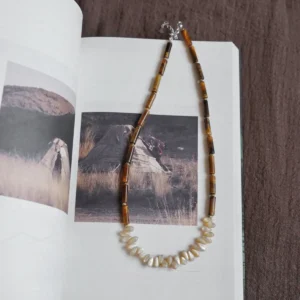 This handcrafted tiger eye and shell necklace features a modern minimalist design, perfect for daily wear and subtle elegance.