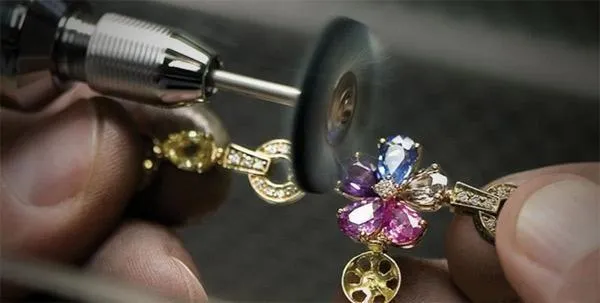 A jeweler meticulously polishing a handcrafted vintage earring to achieve a brilliant, smooth surface finish.