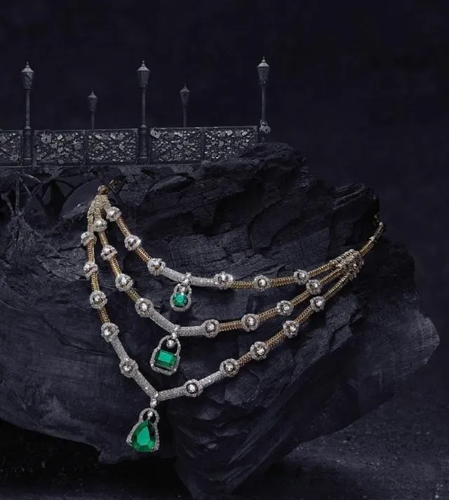 A stunning, heavy-duty gold necklace with brilliant emeralds set into it, crafted according to the Jewelry Setting Quality Guide. This fine jewelry piece is perfect for a luxury collection.