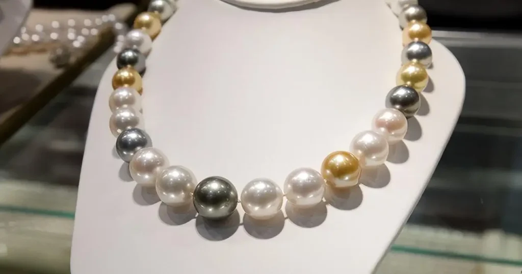 High-quality pearl necklace featuring gold, black, and white pearls with lustrous surface