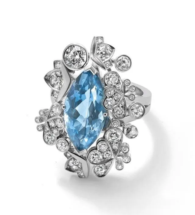 An illustration of a luxury style marquise sapphire and diamond platinum ring. The ring is made of platinum, featuring a large marquise-cut sapphire as the center stone surrounded by multiple layers of smaller diamonds, creating a luxurious design with a striking color contrast.