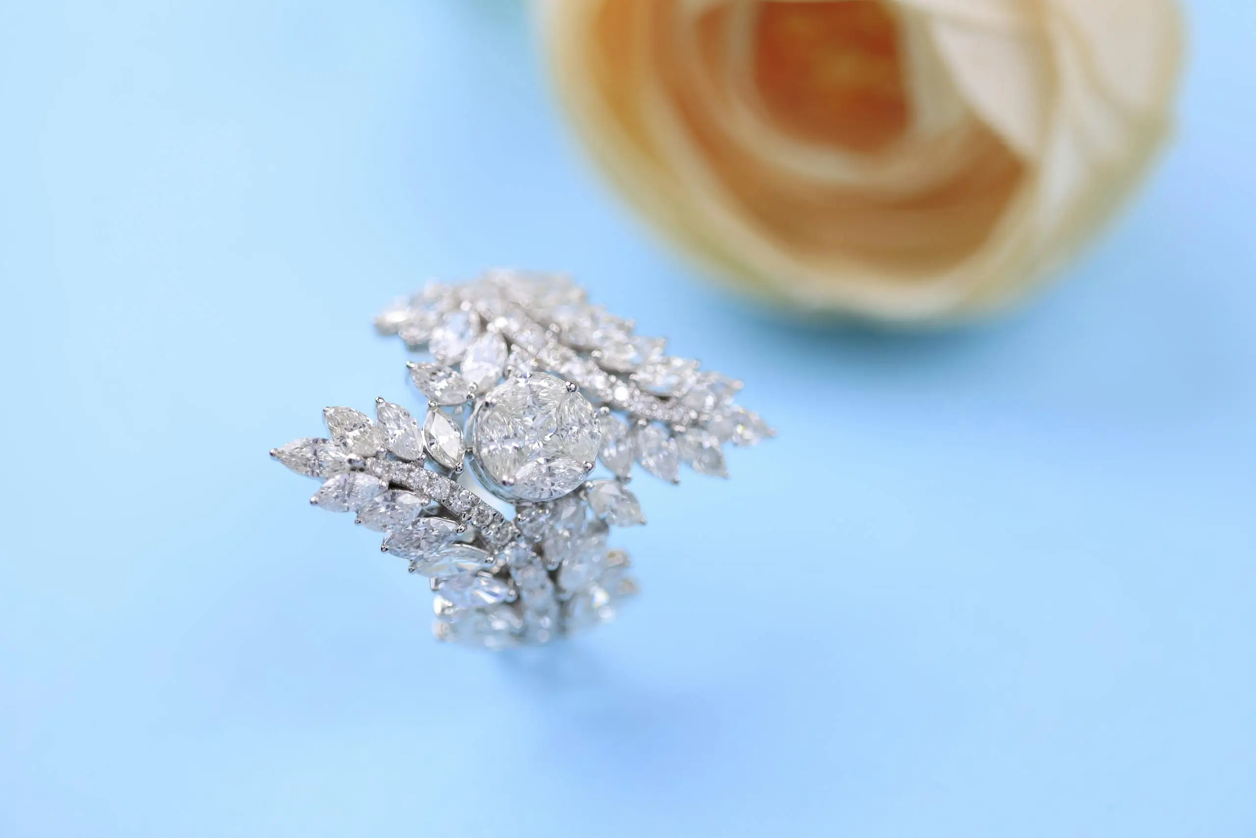 Elegant marquise cut diamond ring with a delicate design on a soft blue background, symbolizing timeless luxury and refined style.