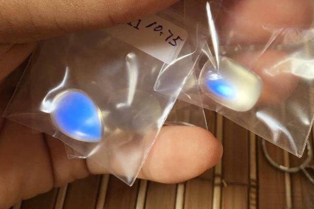 Bottom of a drop-shaped moonstone showing stronger and more extensive blue adularescence under the same lighting.