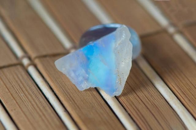 Close-up of a moonstone rough showing delicate blue adularescence and natural surface texture.