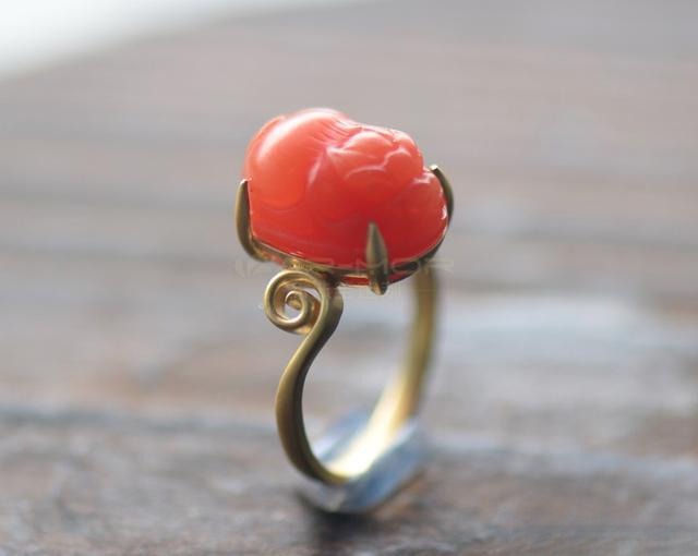 Gold ring featuring a polished red agate stone, elegant and glossy design.