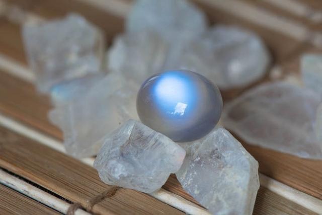 Oval moonstone June birthstone featured in Art Nouveau jewelry at the turn of the century, showcasing its soft blue adularescence.