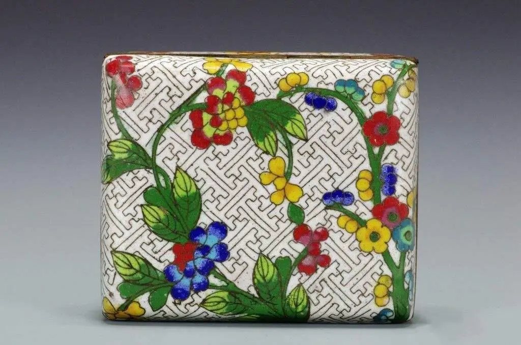 An image of a late Qing to early Republic-era cloisonné enamel box. The box's surface is decorated with a continuous swastika pattern, outlined with fine metal wires and filled with colorful enamel. The vibrant colors and delicate craftsmanship are characteristic of cloisonné from this period.