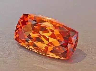 A close-up of a single brilliant-cut orange topaz gemstone, highlighting Topaz colors and value through its vibrant hue and precise facets.