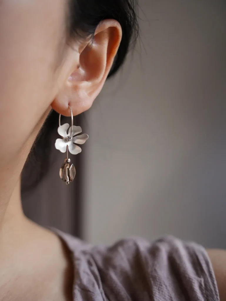 Woman wearing handmade earrings, showcasing elegant vintage style and daily wearable design.