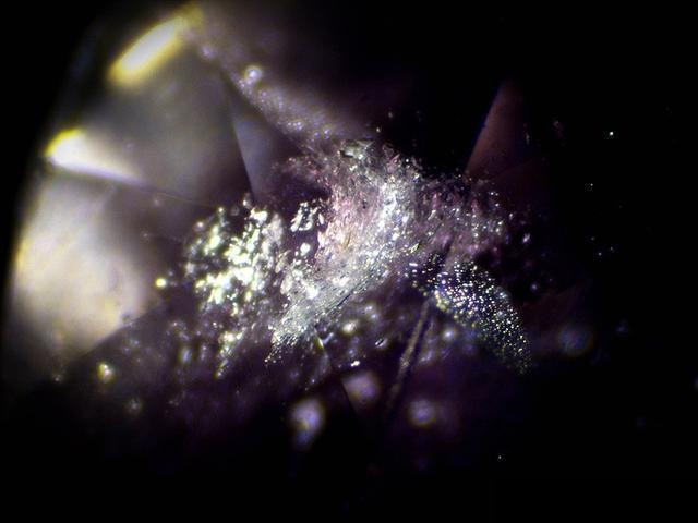 Microscopic view of Vietnam pink sapphires showing white, translucent, frost-like inclusions resembling tiny ice cracks