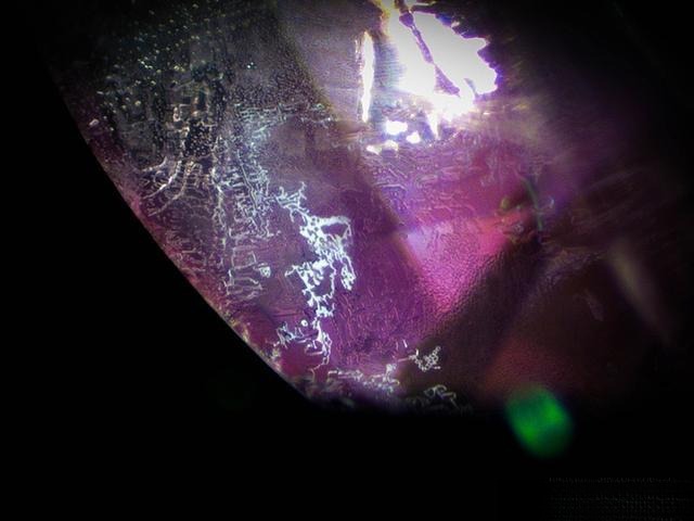 Microscopic view of Vietnam pink sapphires showing blue areas forming fine white streaks along crystal growth planes
