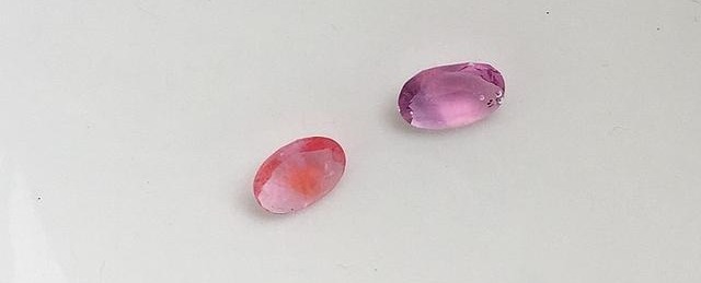 Two Vietnamese sapphires in clear water showing yellow-orange inclusions resembling rusted iron.