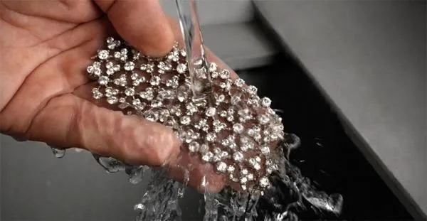A pair of vintage handcrafted earrings undergoing a final cleaning process to remove residues and enhance their sparkle.