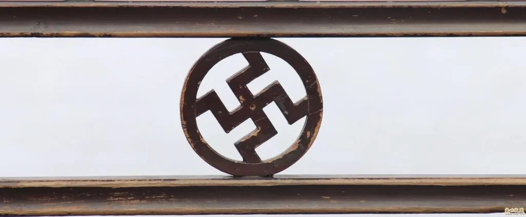 An image of a Chinese clothes rack decorated with the swastika (Wan character) pattern. The rack is made of wood, and the intricate carvings or openwork details feature the repeating motif, symbolizing good fortune and eternity. It serves as an example of the pattern's use in daily household items.