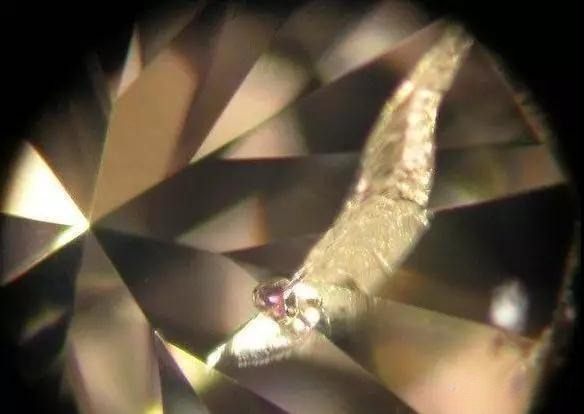 Close-up of the diamond showing delicate feather pattern on the right side